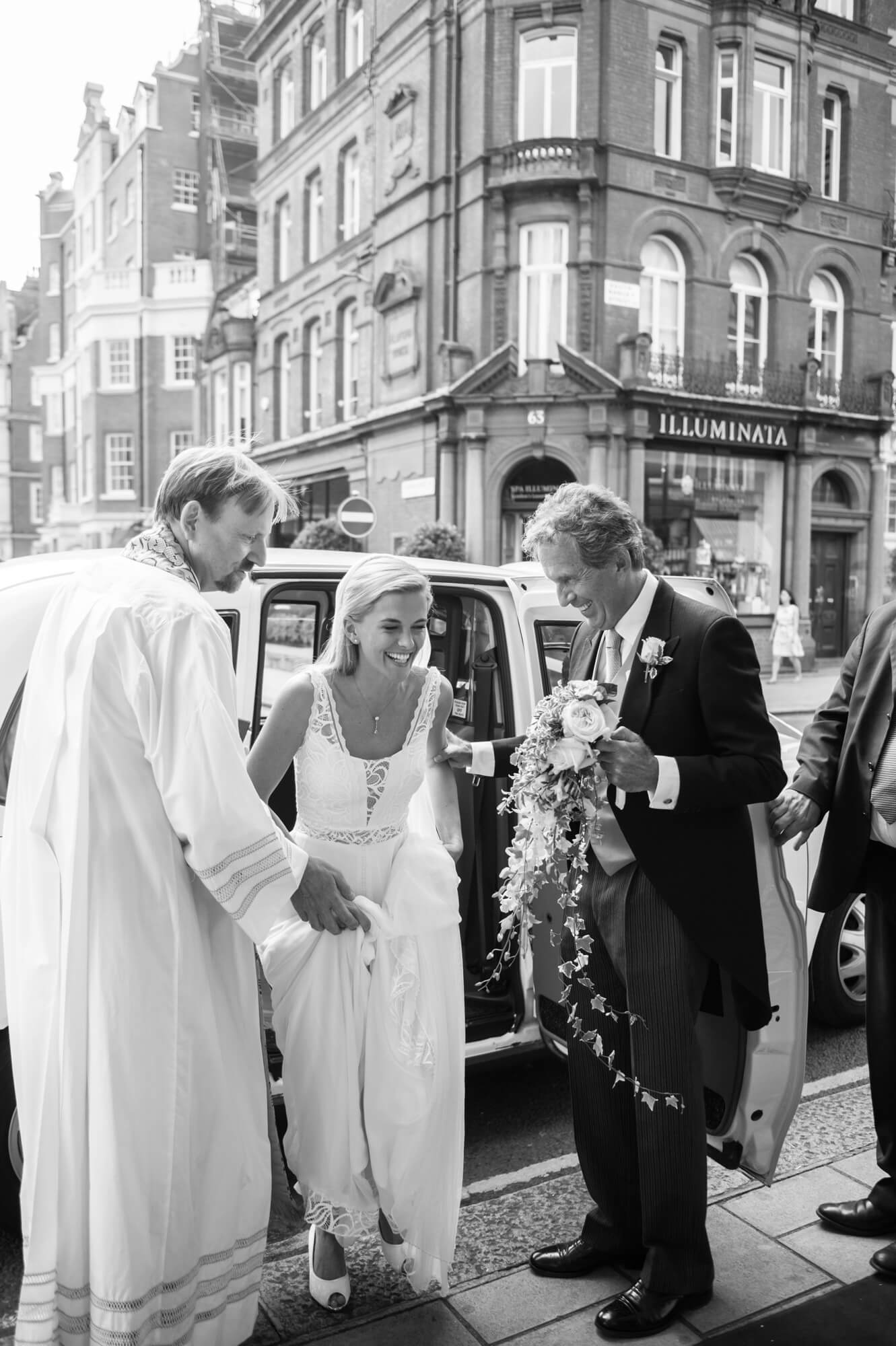 A bride getting out of a taxi in London